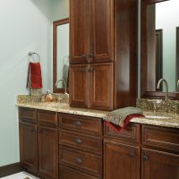 A bathroom with a dark wood vanity, granite countertops, and a pair of wall-mounted sinks.