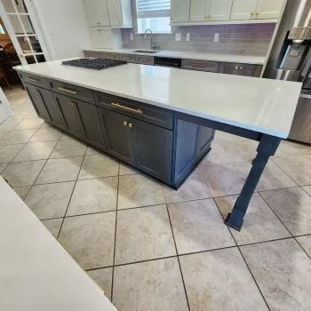 Large kitchen with dark gray island cabinetry and light gray and painted periphery cabinetry