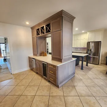 Peninsula Kitchen Cabinetry, light brown cabinetry with gold hardware and white quartz countertops