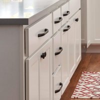 Version 1.0.0 An image showing a kitchen cabinet with white drawers and black hardware.