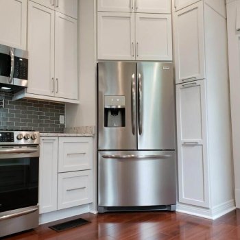 Corner fridge enclosure with pull out pantry