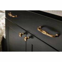 Close-up view of black cabinet drawers with brass hardware and fixtures