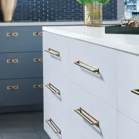 A close-up view of the kitchen cabinets, showing the green color and gold hardware details