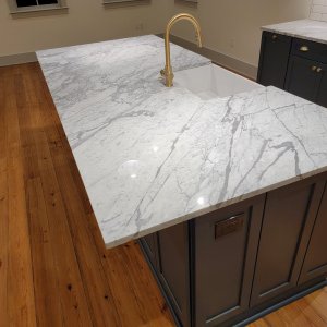 Showcase natural veining with local New Orleans marble countertops. This side profile captures the soft, sweeping gray veining characteristic of genuine Carrara marble. French Quarter Facades seals and polishes every slab to ensure your historic Algiers Point kitchen remodel looks pristine for a lifetime. Side view of a premium Carrara marble kitchen island countertop showing natural gray veining, installed by French Quarter Facades in Algiers Point.
