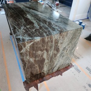 Breathtaking New Orleans quartzite countertops custom fabricated for a historic property in the Irish Channel neighborhood of Orleans Parish. This dramatic waterfall island is cut from exotic Verde Esmeralda Quartzite, showcasing a continuous vein match through a precise 45-degree miter. New Orleans quartzite countertops featuring a custom Verde Esmeralda Quartzite waterfall island with continuous mitered veining in the Irish Channel neighborhood.